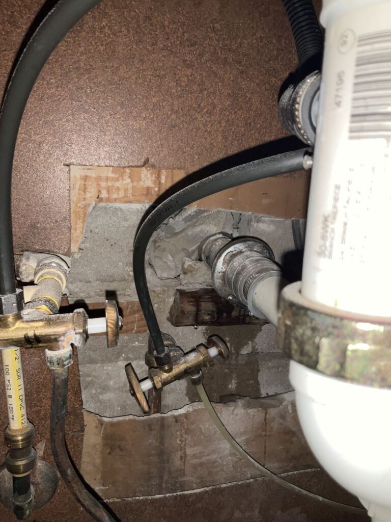 Brass gas shutoff valve and a flexible gas connector running through a wall penetration
