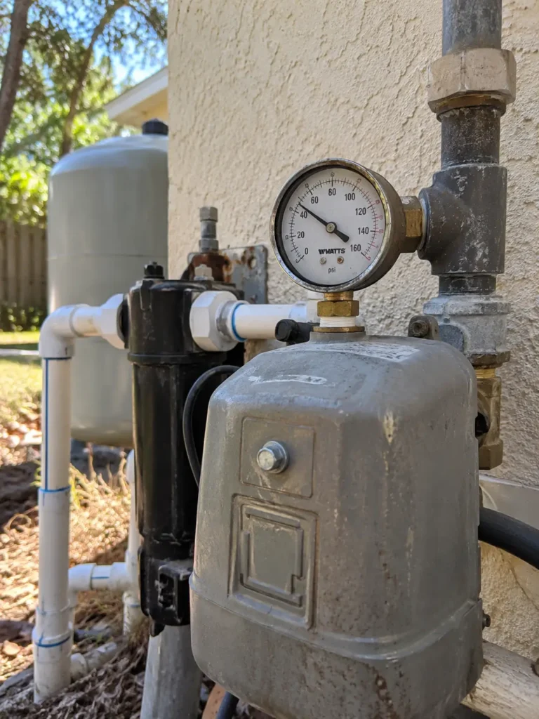 Close view of the pressure gauge and pressure switch on a galvanized well tank